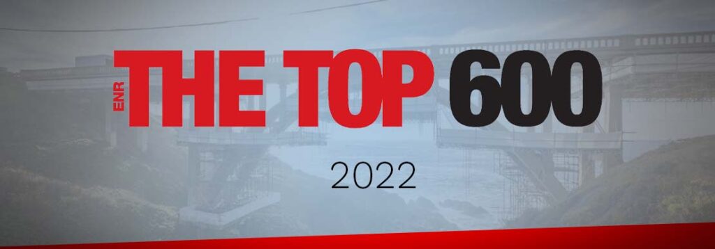 A banner with the text ENR THE TOP 600 2022 in large bold red and black letters, set against a faded background image of a bridge under construction.