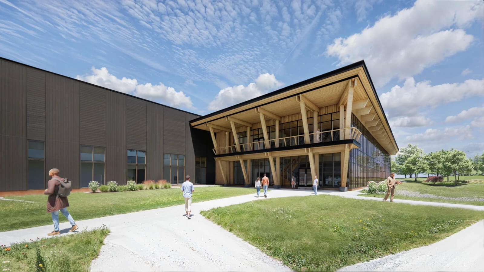 A modern building with a large wooden overhang and glass facade sits beside a dark metal structure. Several people walk on paths across a grassy area under a partly cloudy sky.